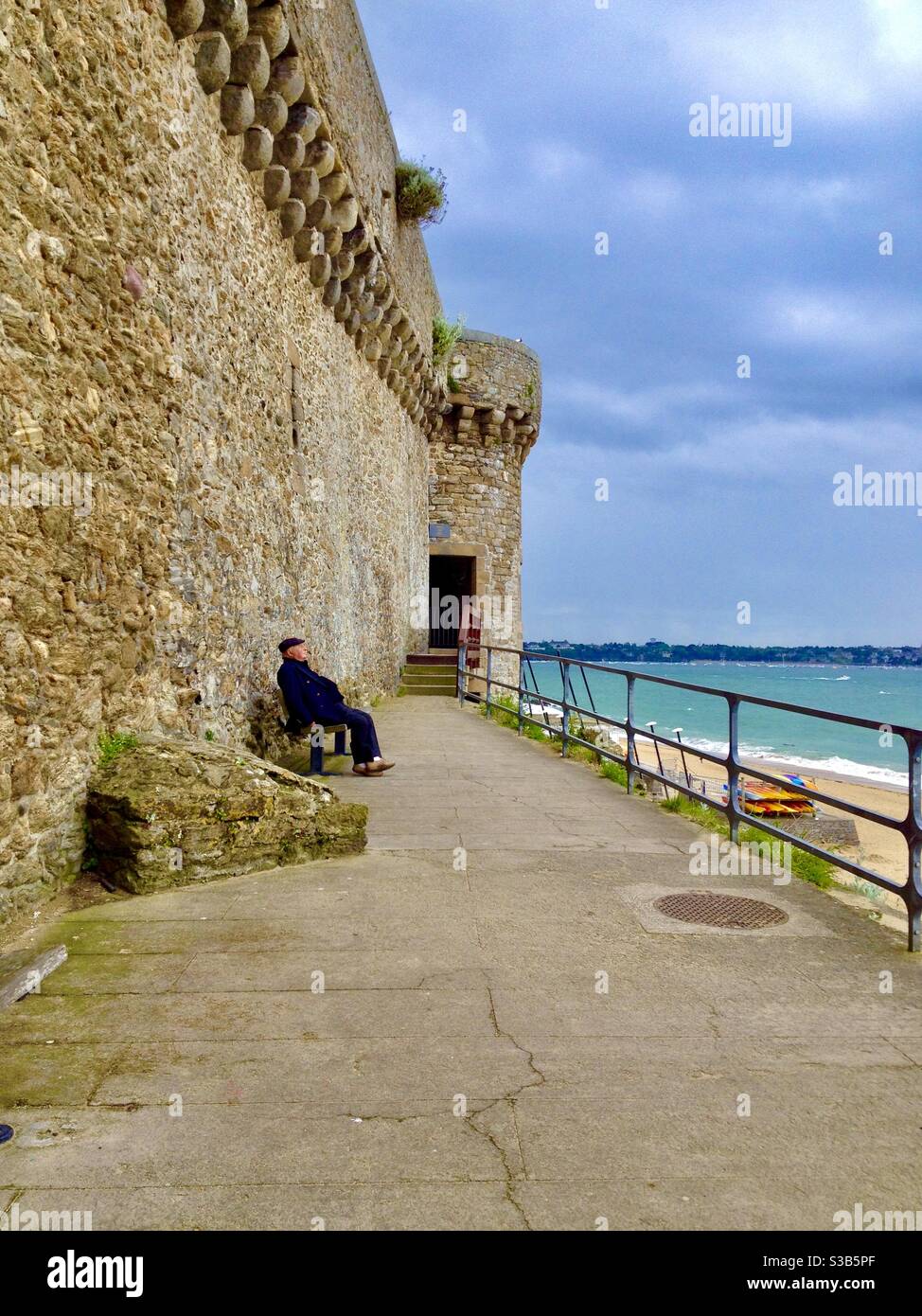 Older gentleman enjoying an ocean view by Fort National, formerly named Fort Royal, in Saint-Malo, Brittany, France. Stock Photo