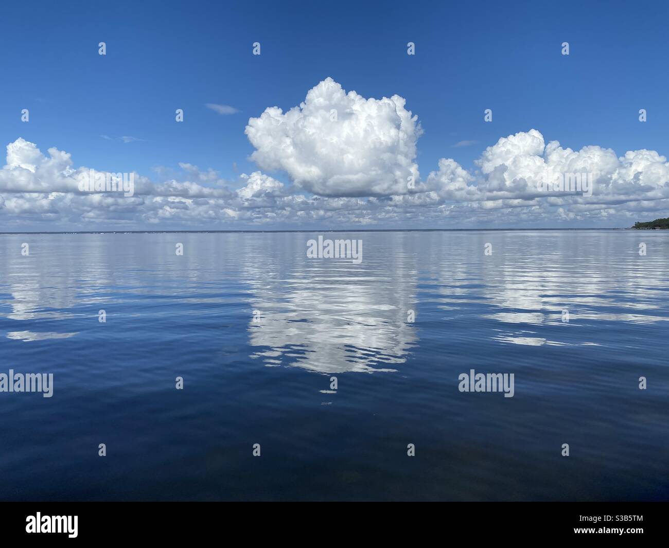 Large white fluffy cloud reflecting onto deep blue Gulf of Mexico water ...