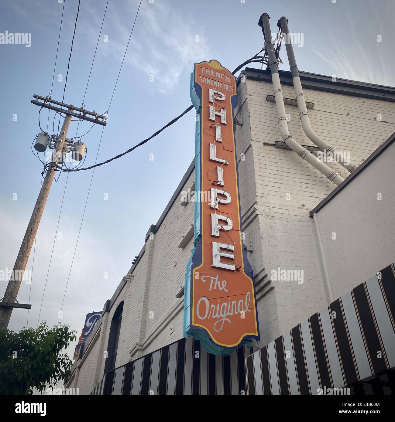 LOS ANGELES, CA, AUG 2020: looking up at blade sign at Philippe 'the Original' restaurant building in Downtown. Power lines overhead - Smartphone Captured Stock Image
