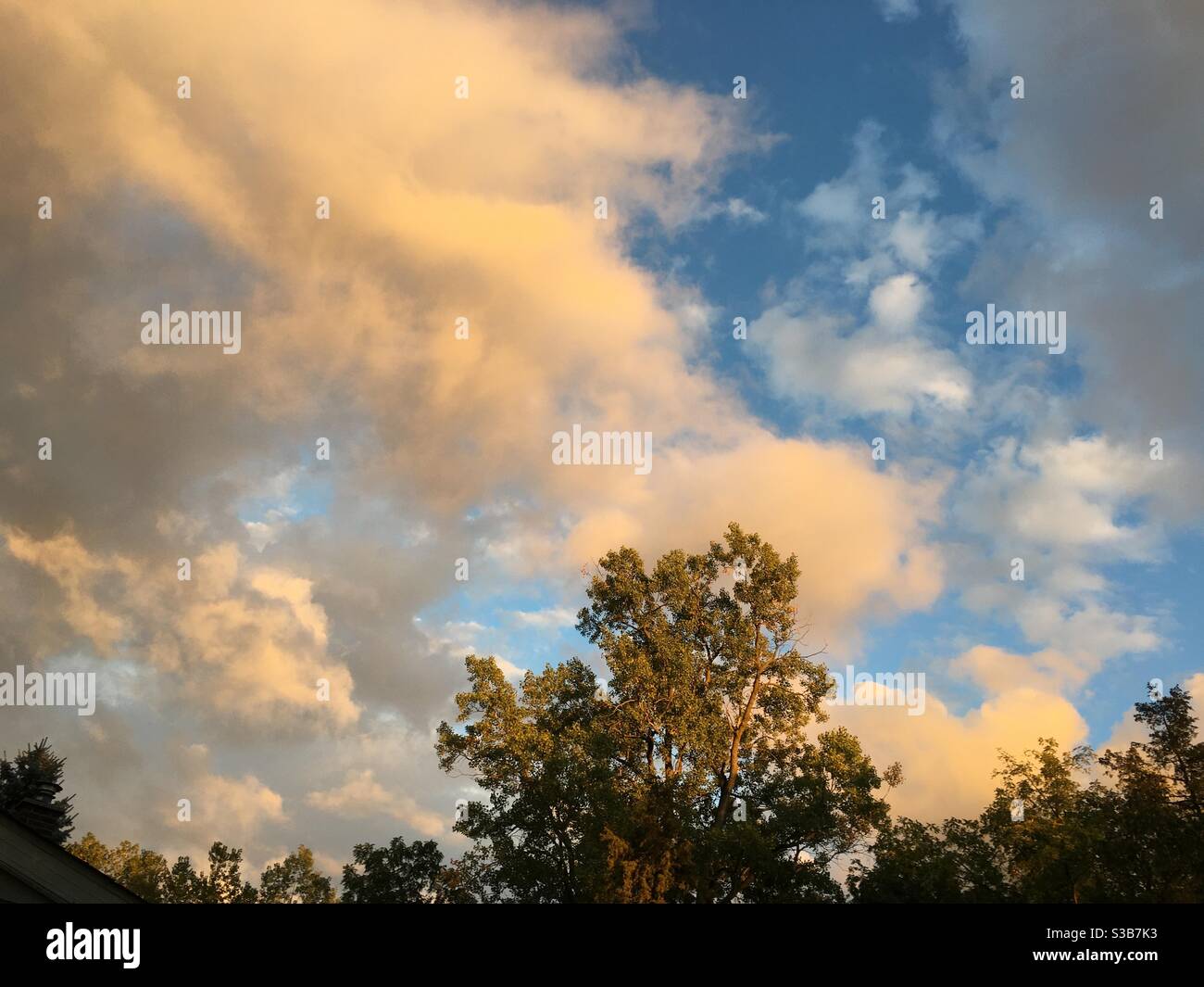 The evening sun colors the clouds on a fall day in Michigan. Stock Photo