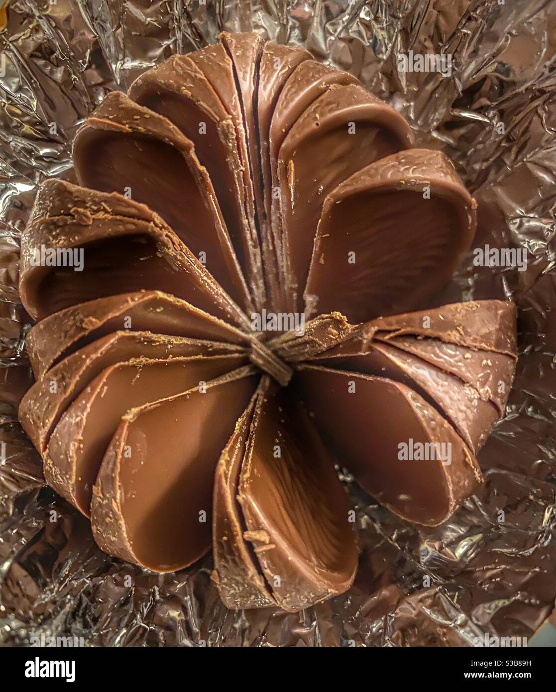 Opened chocolate orange in segments in a foil wrapper Stock Photo Alamy