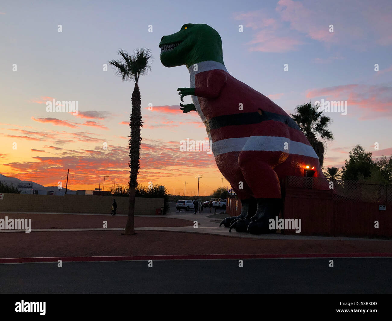 Palm Springs, USA. 12th Nov, 2020. The Cabazon dinosaur dressed up like Santa Claus at sunset just outside Palm Springs. - Smartphone Captured Stock Image