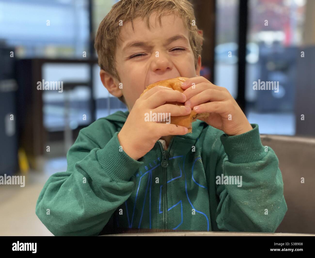 Toddler eating burger - Smartphone Captured Stock Image