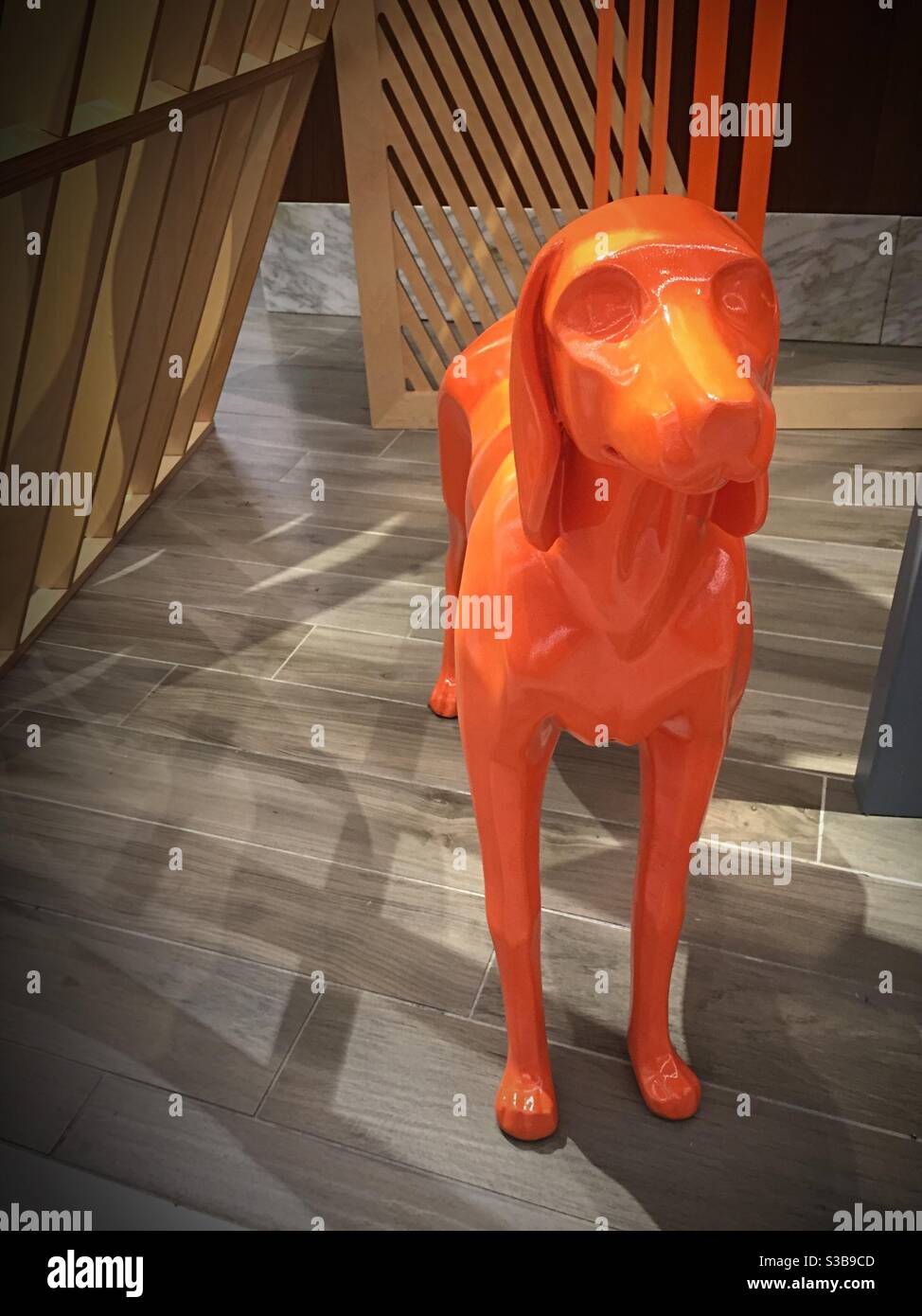 Decoration in a store of a large plastic orange dog, USA - Smartphone Captured Stock Image