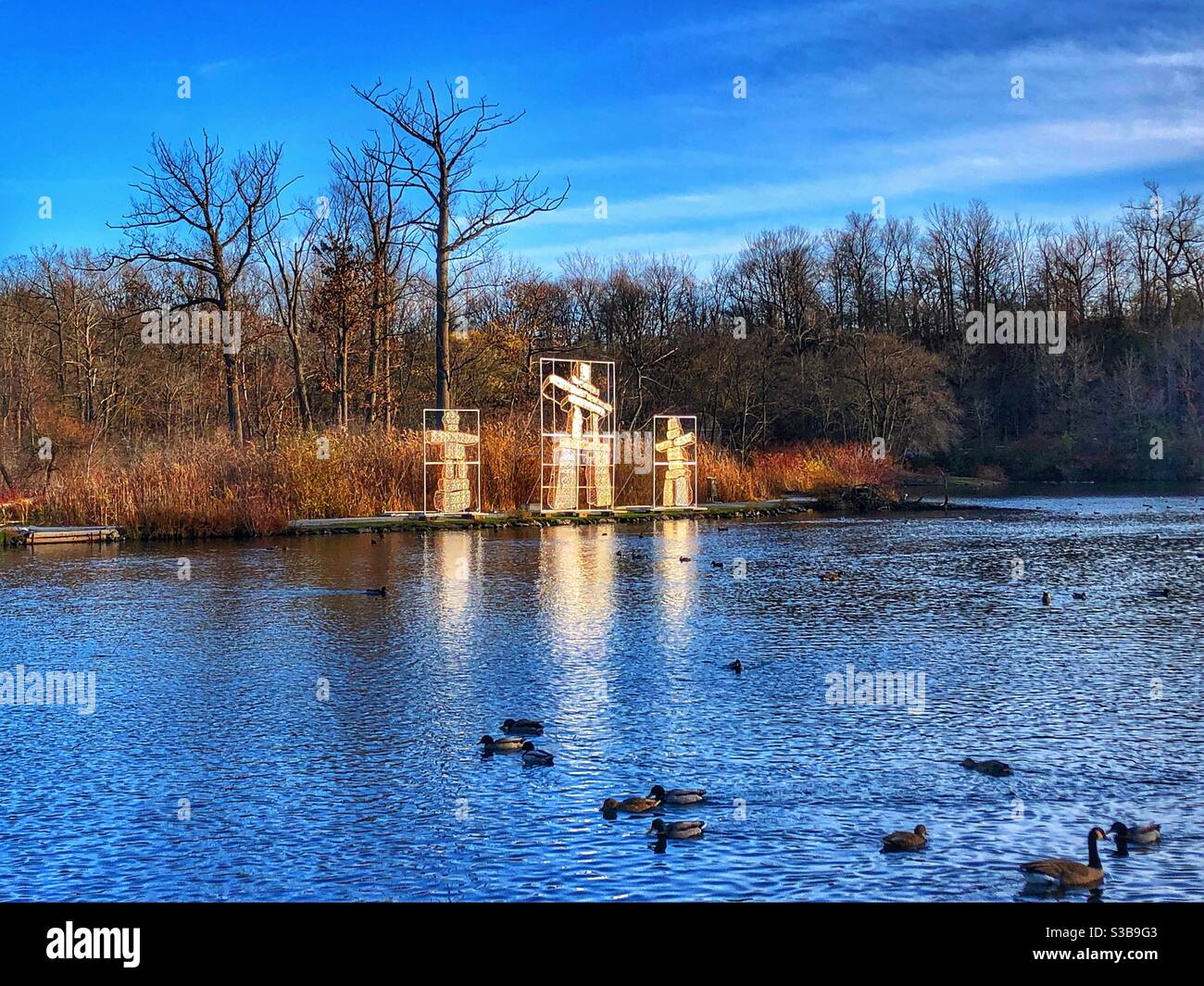 Three Inukshuks lit up on the shoreline. - Smartphone Captured Stock Image