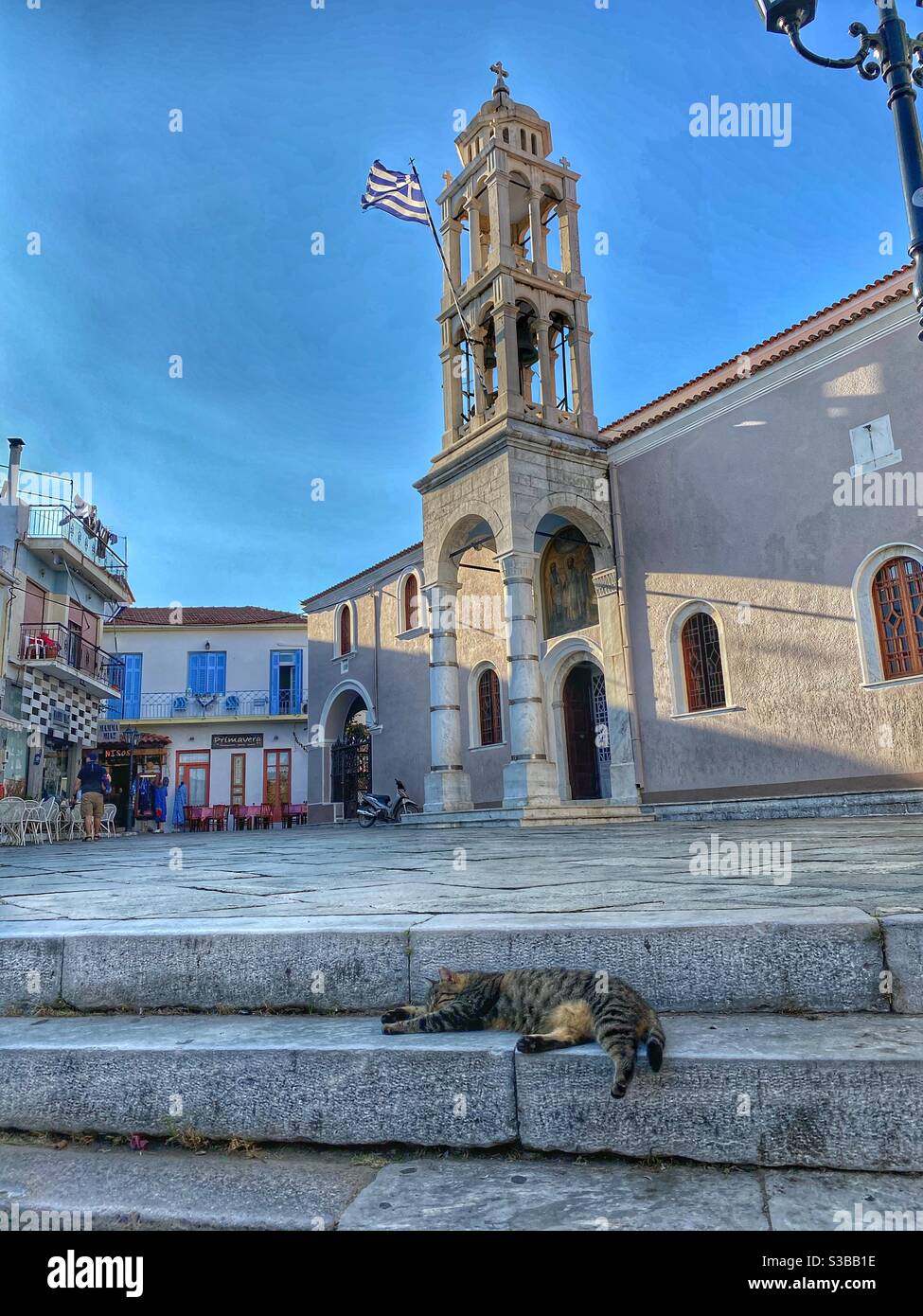 Car sleeping in front of Cathedral of Three Hierarchs in Skiathos town. - Smartphone Captured Stock Image