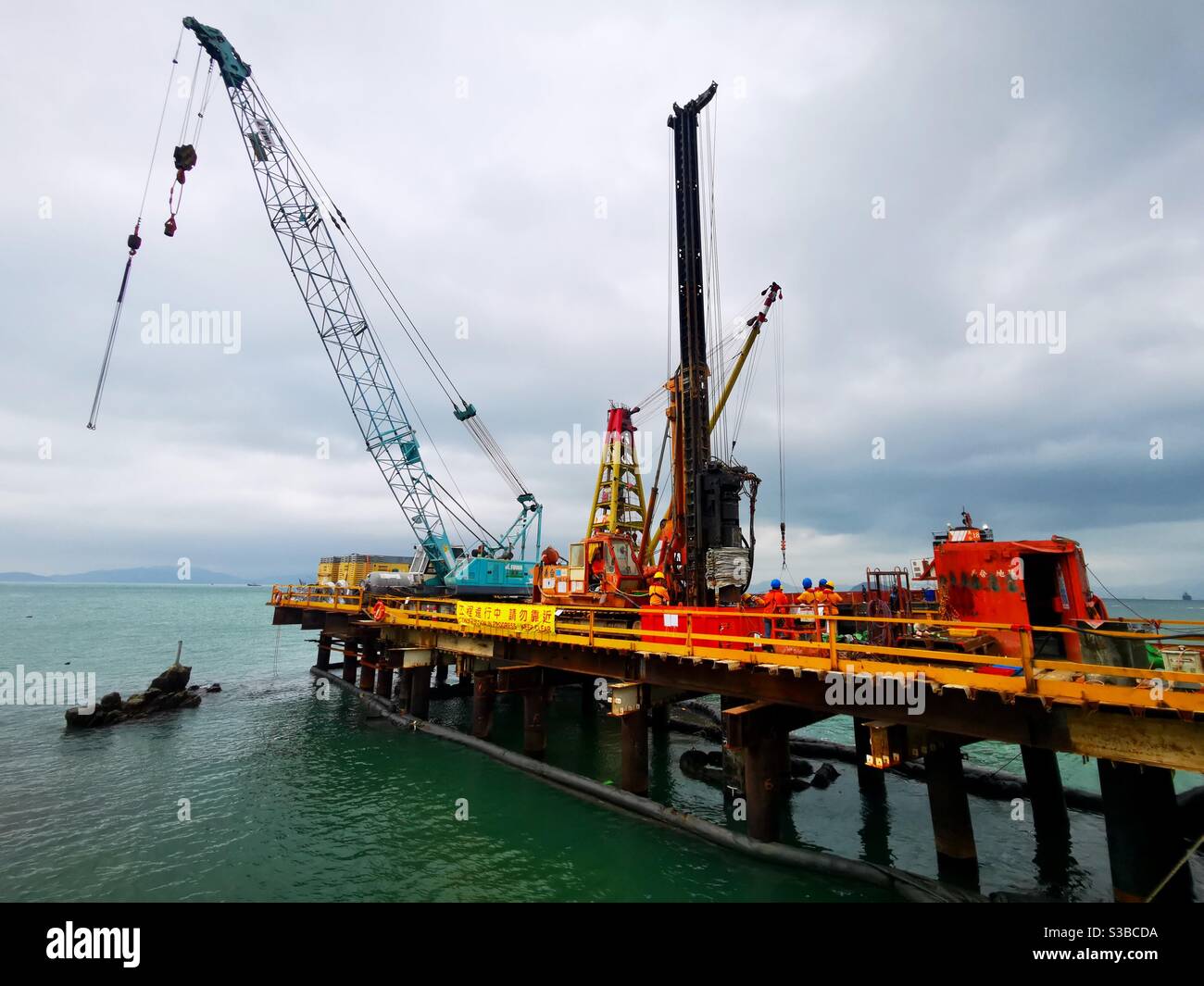 construction workers working on the bew Pak Kok pierv on Lamma island in Hong Kong. - Smartphone Captured Stock Image
