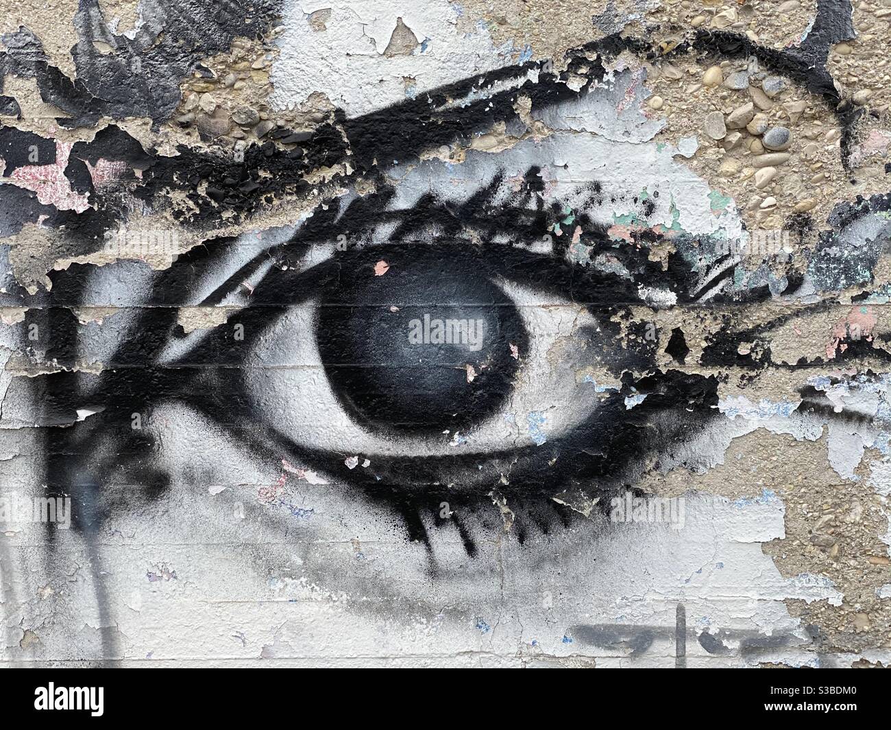Detail view of a female eye design over an unskilled wall - Smartphone Captured Stock Image