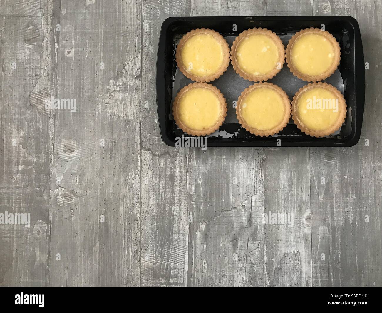 Individual lemon tartlets on a wooden background - Smartphone Captured Stock Image