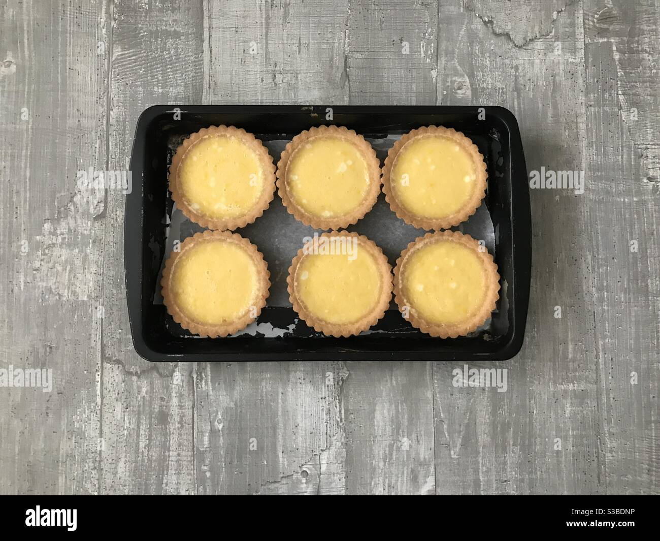Individual lemon tartlets on a wooden background - Smartphone Captured Stock Image