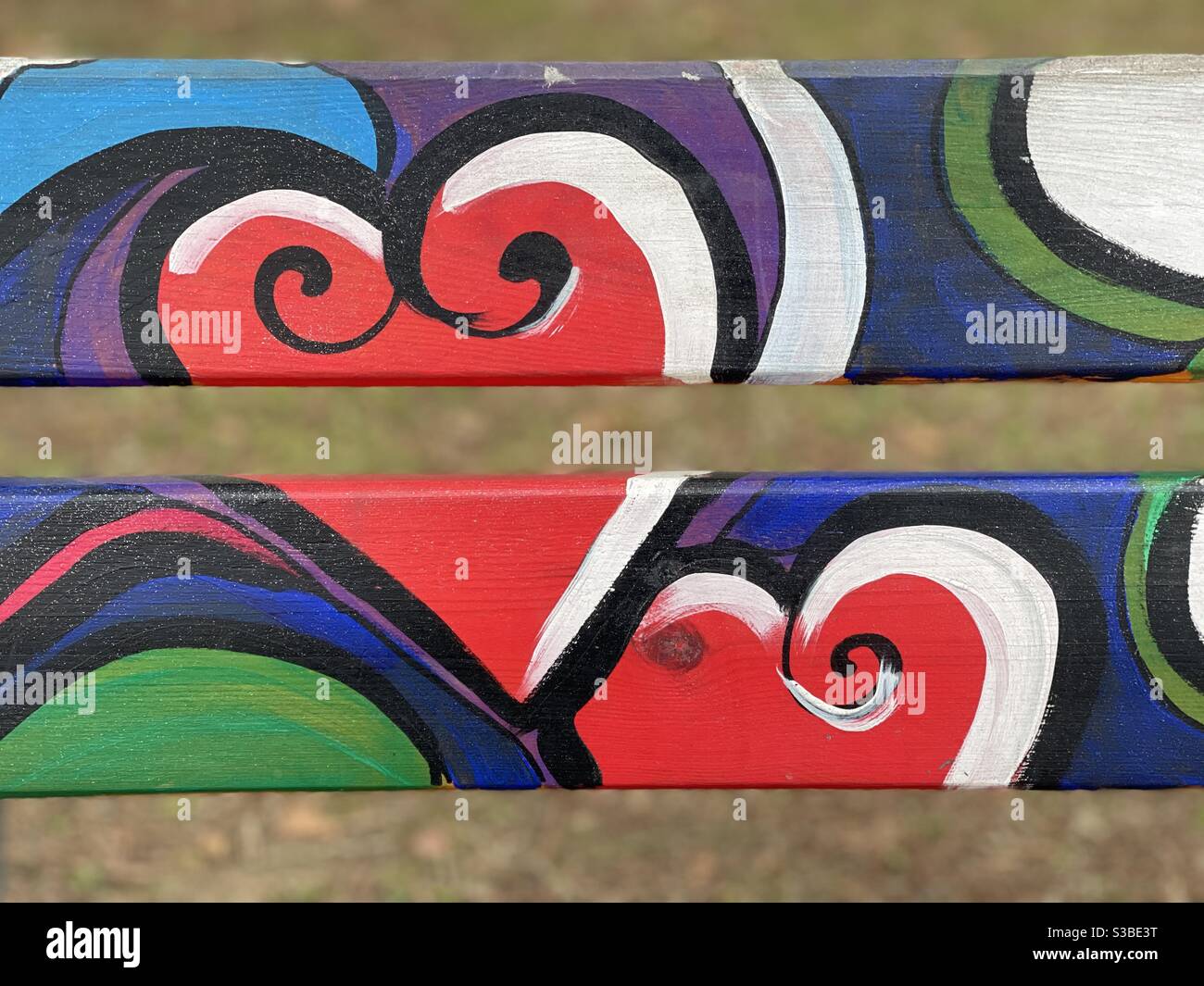 Creative urban art design with two hearts painted on a public bench Stock Photo