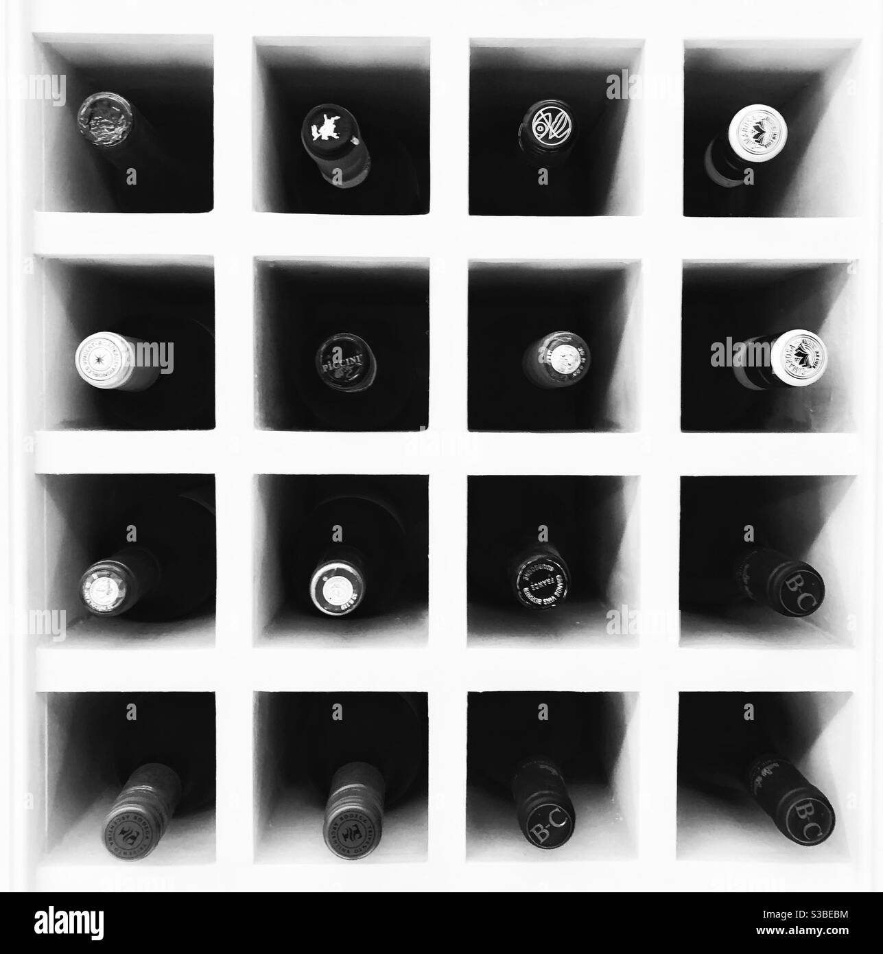 Graphic, high contrast black and white still life of wooden wine rack with bottles shot head on. - Smartphone Captured Stock Image