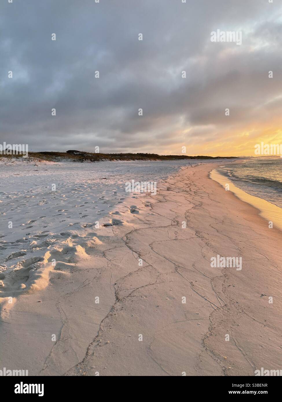 Sunrise on white sand Florida beach with view of shoreline and sand