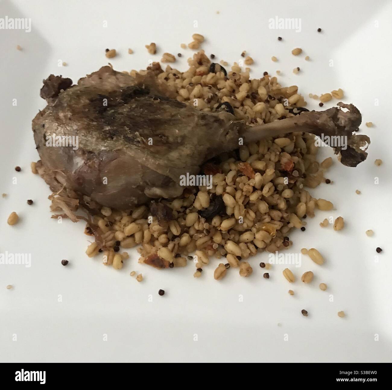 Pan fried confit duck leg on a wooden background Stock Photo