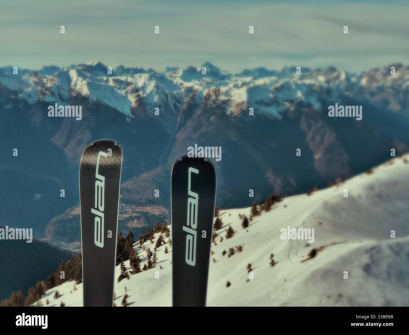 Skis stuck in snow at Zoncolan Ski resort, Friuli Venezia Giulia, Italy. Dolomites mountains in the background. - Smartphone Captured Stock Image