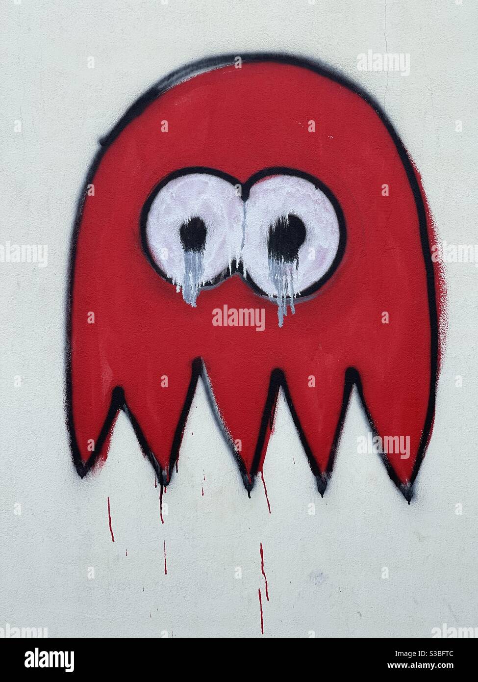 Crying creative emoticon painted on a wall Stock Photo