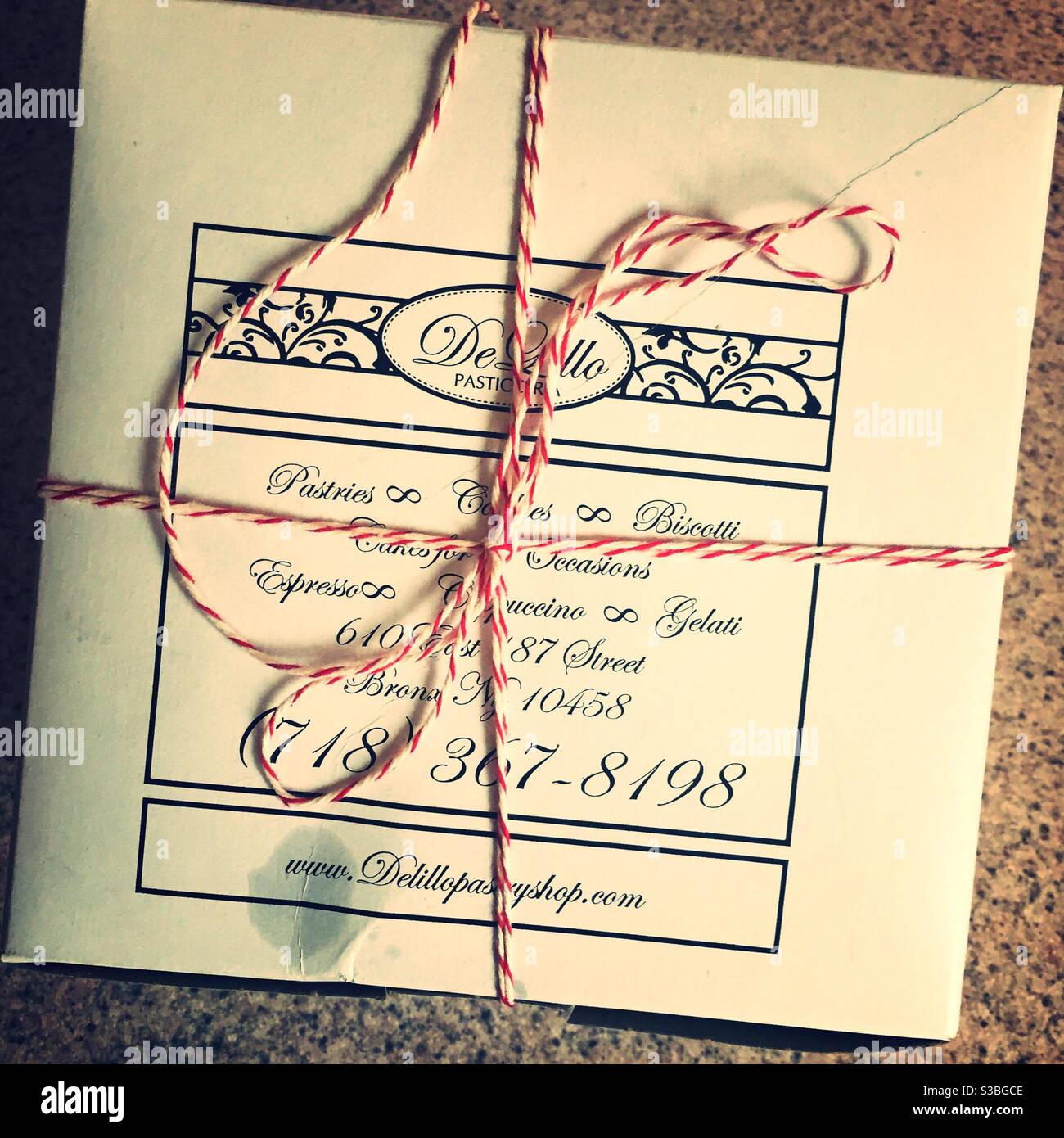 Bakery box wrapped in red and white string from a famous pastry shop in the Bronx, NYC, USA - Smartphone Captured Stock Image
