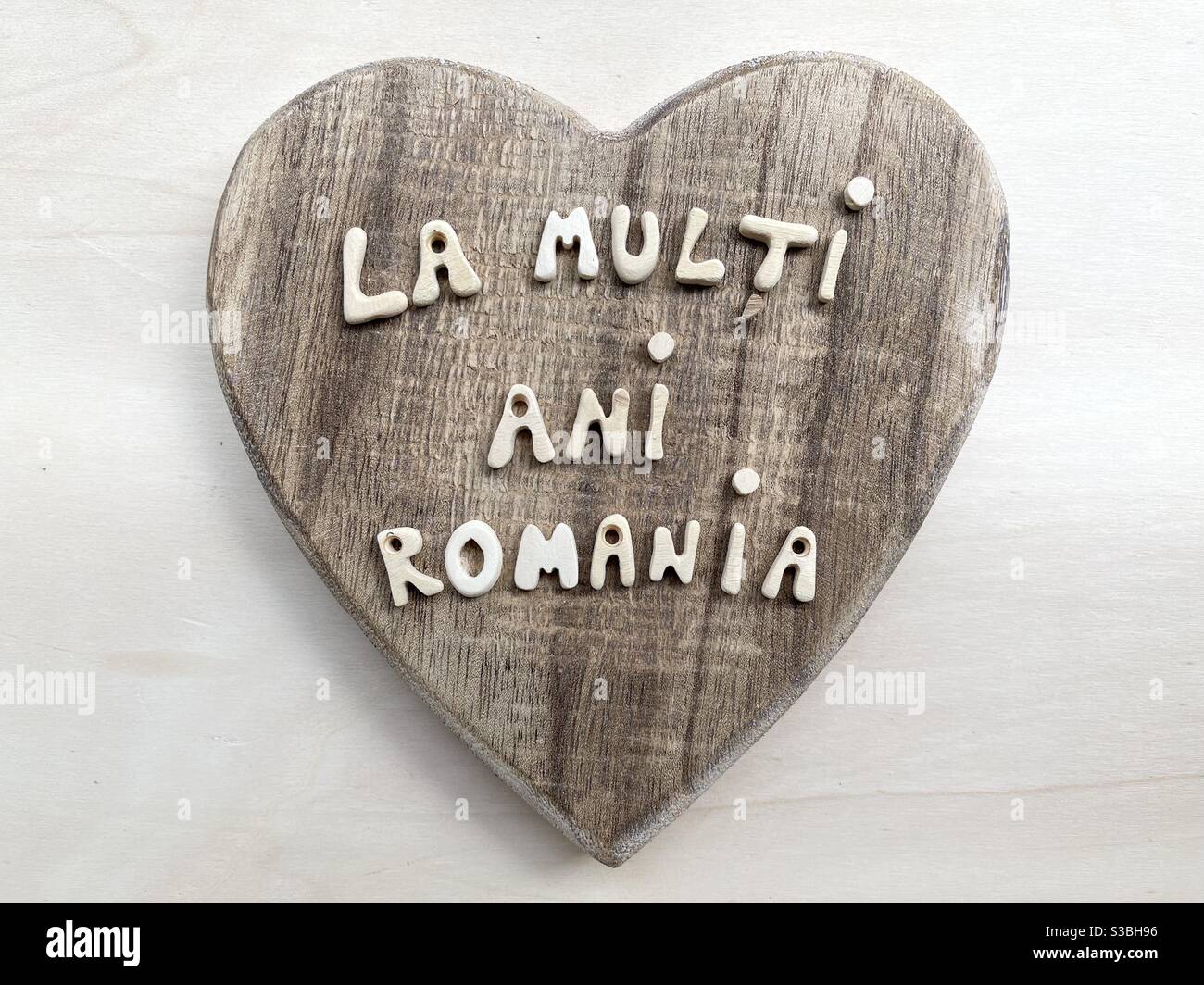 Romania, National Day, creative celebration with wooden letters over a wooden heart Stock Photo