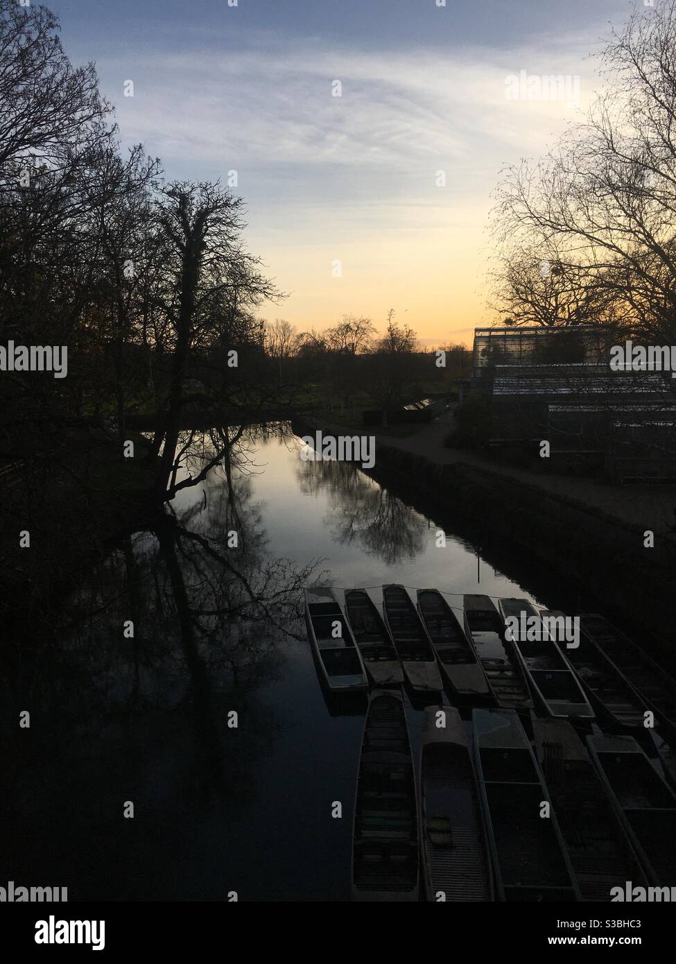 Punts moored on the river Cherwell in Oxford at sunset, seen from Magdalen Bridge. Stock Photo