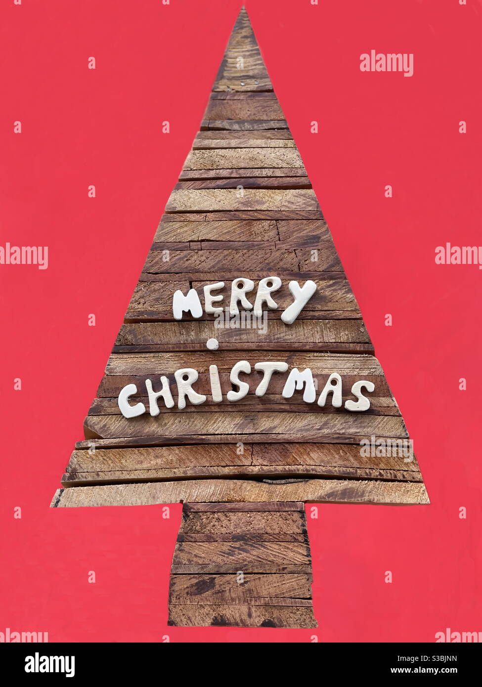 Merry Christmas message with wooden letters on a wooden stylized christmas tree - Smartphone Captured Stock Image