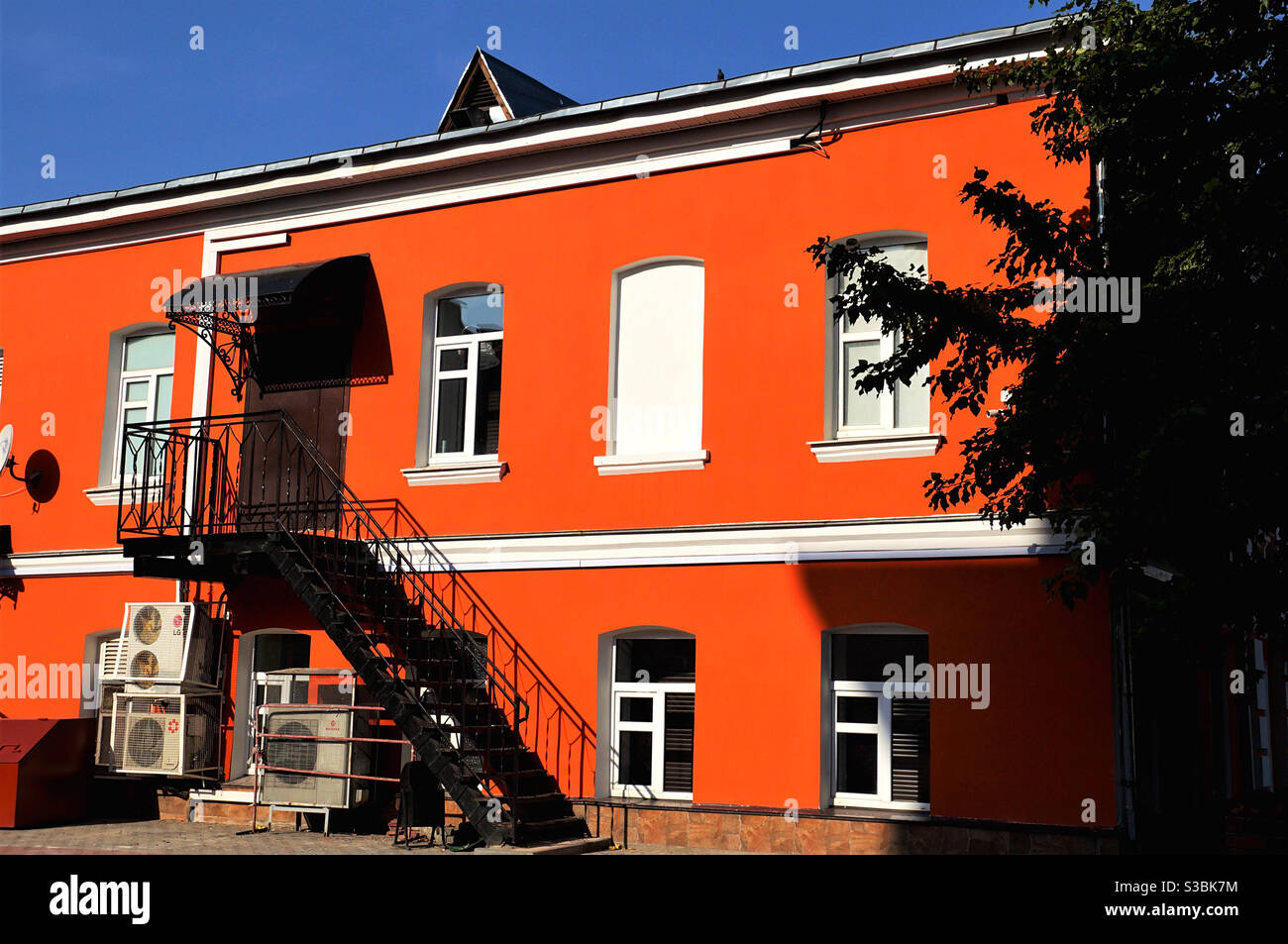 Bright red wall of old building in sunlight Stock Photo
