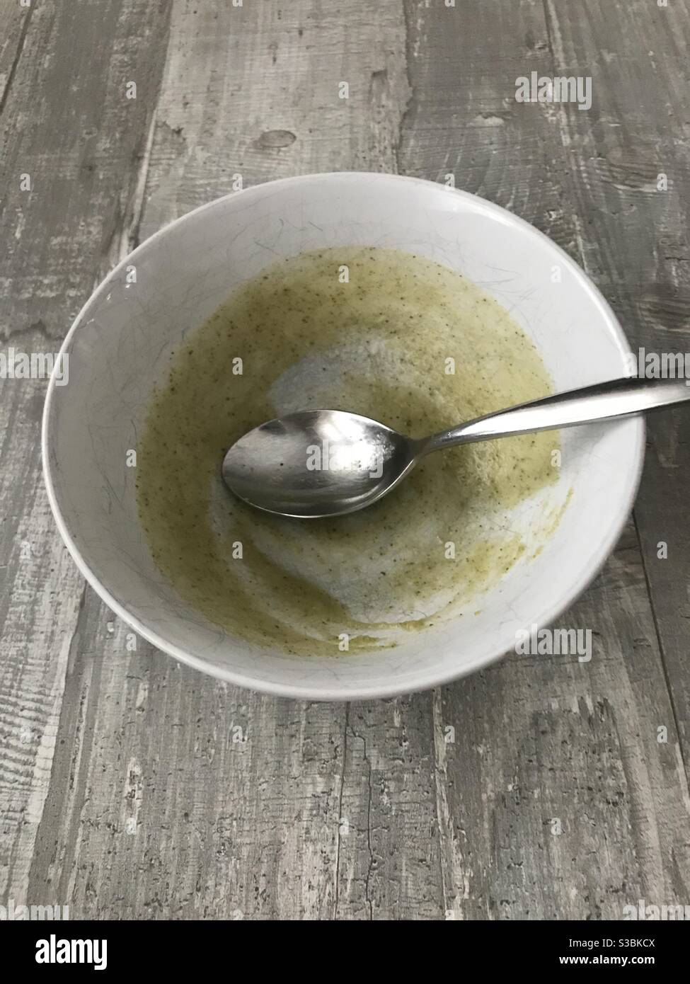 An empty bowl of homemade broccoli soup on a wooden background - Smartphone Captured Stock Image