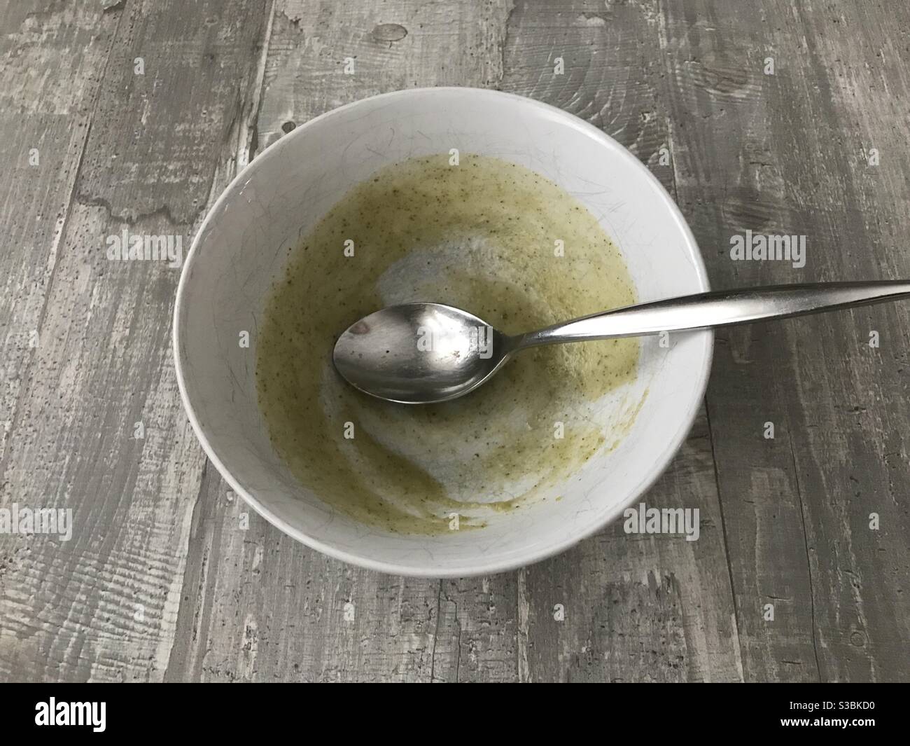An empty bowl of homemade broccoli soup on a wooden background - Smartphone Captured Stock Image