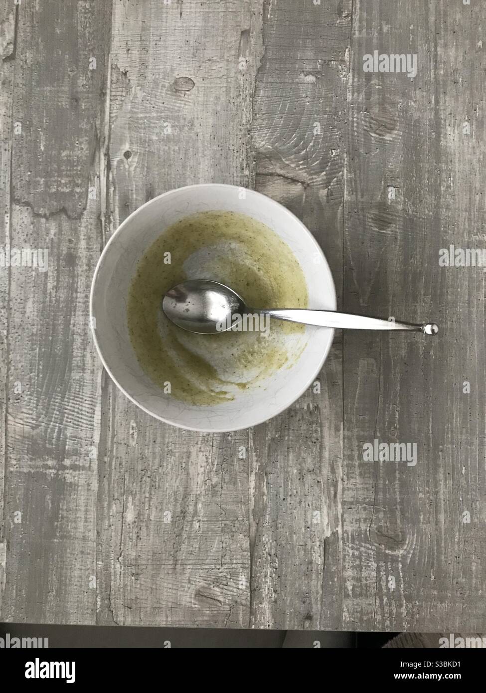An empty bowl of homemade broccoli soup on a wooden background - Smartphone Captured Stock Image