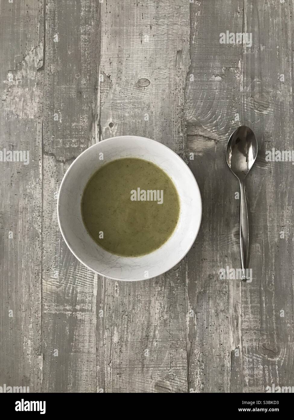 An empty bowl of homemade broccoli soup on a wooden background - Smartphone Captured Stock Image