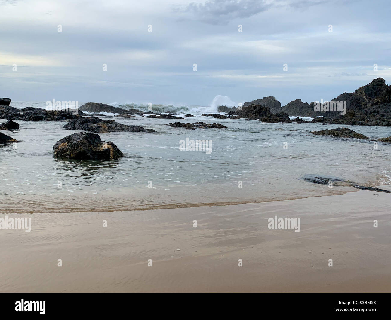 The rocky end of the beach, water lapping on the shore. A lovely walk - Smartphone Captured Stock Image