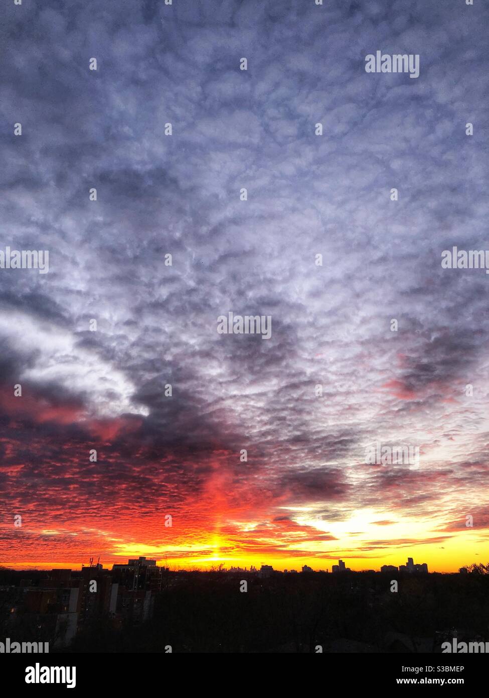 Dramatic sunset sky with a face in the clouds. - Smartphone Captured Stock Image