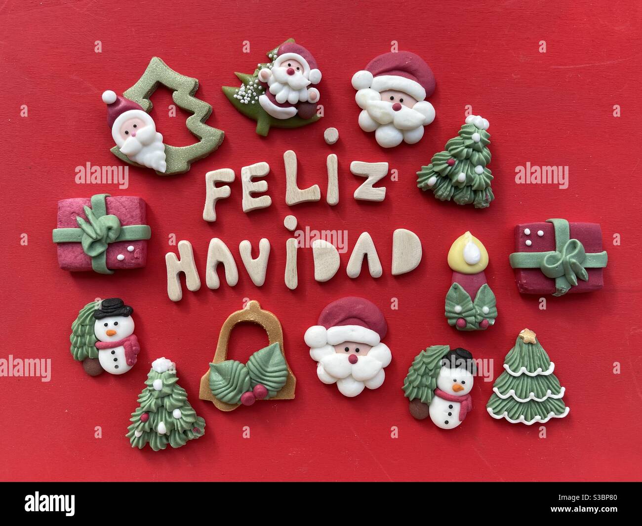 Feliz Navidad, Merry Christmas in spanish language with wooden letters and marzipan Christmas symbols Stock Photo