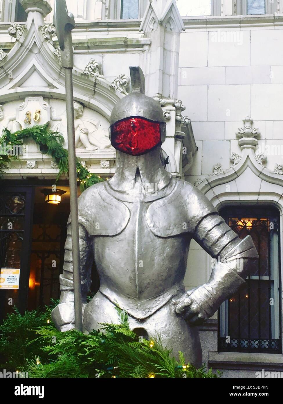 A statue of an armored knight stands guard in front of a luxury apartment building in Gramercy Park during the 2020 pandemic, NYC, USA - Smartphone Captured Stock Image