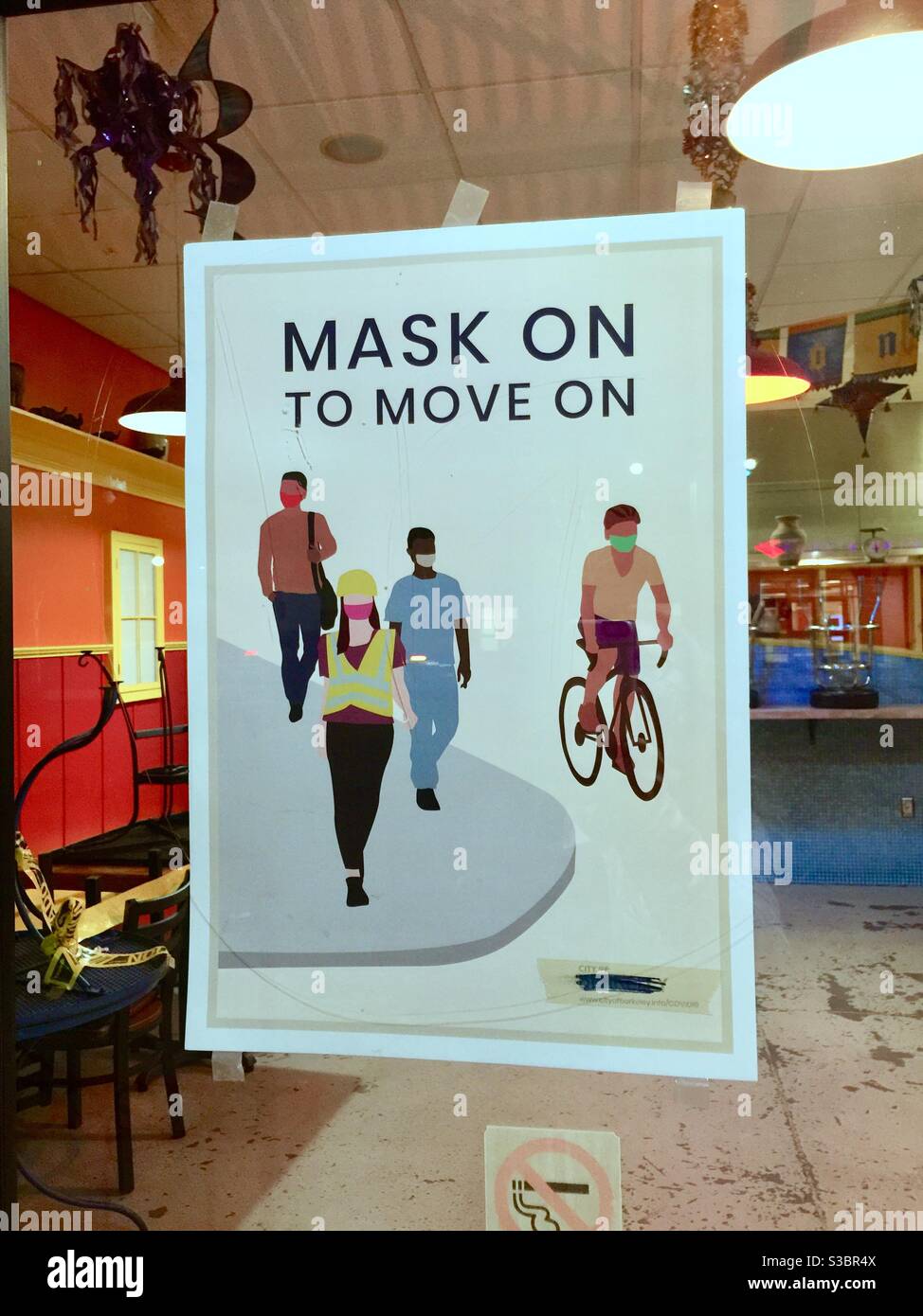 A sign at small restaurant that says “Mask On To Move On”. Practice safety and wear a mask to prevent COVID spread and infection. Stock Photo