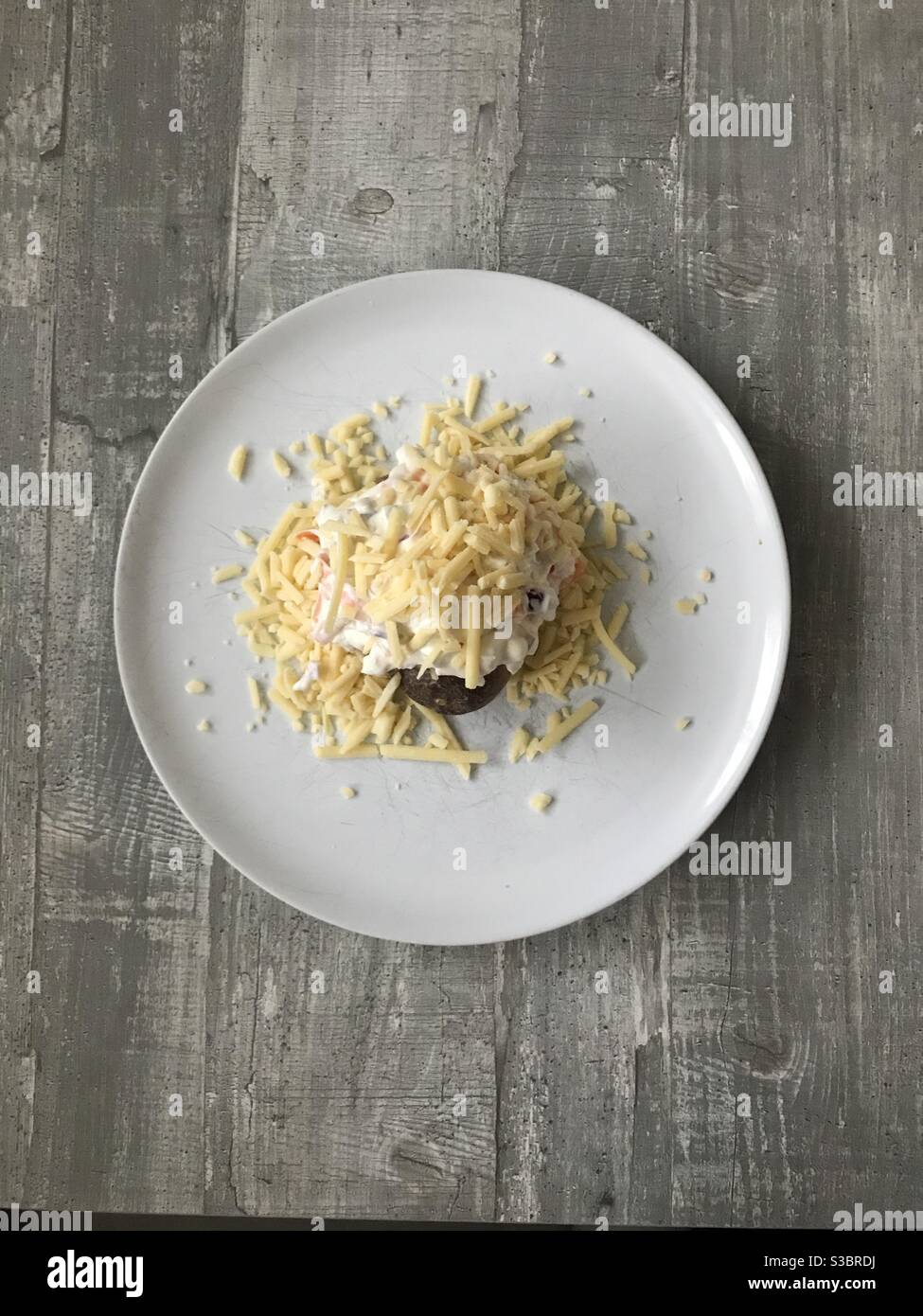 Oven baked potato filled with homemade coleslaw and grated cheese - Smartphone Captured Stock Image