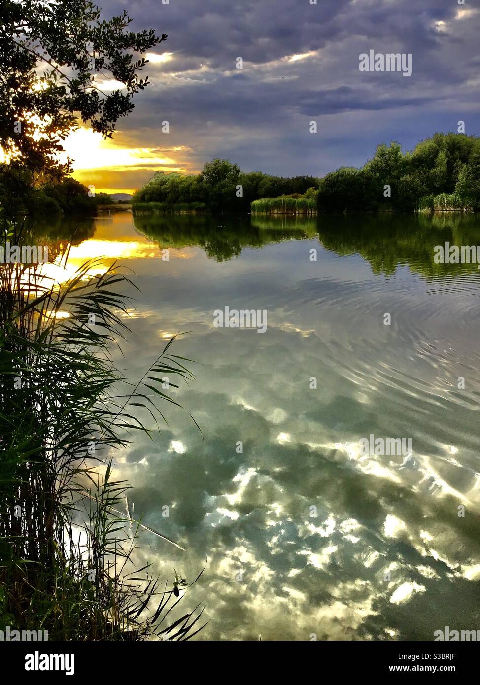 Lake with reflections at sunset Stock Photo