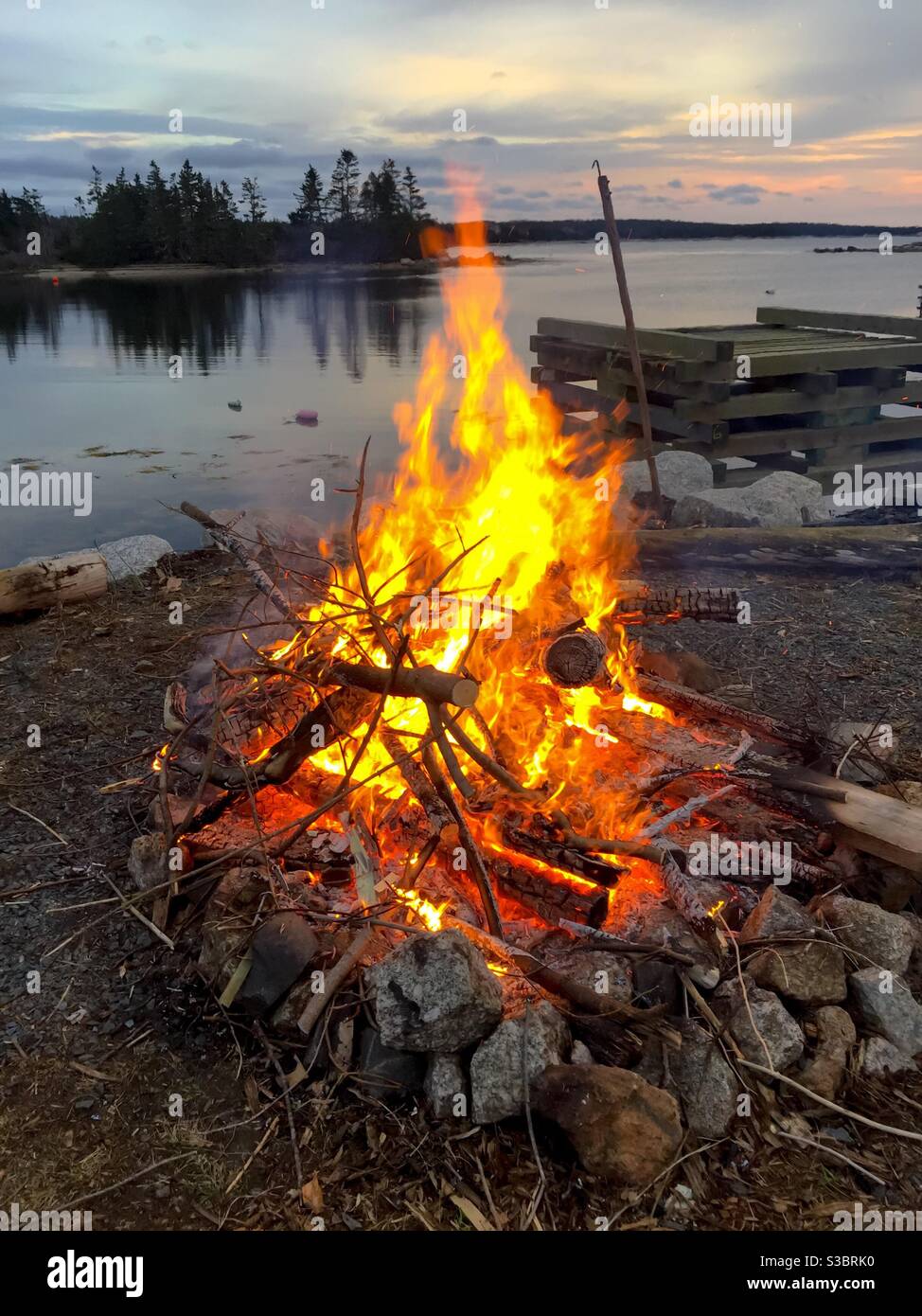 Bonfire by the sea, Nova Scotia, Canada. Safe, authorized, outdoor disposal. - Smartphone Captured Stock Image