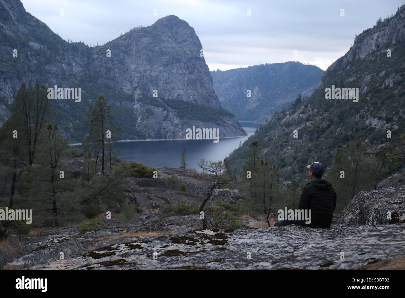 Backpacker in camp overlooking hetch hetchy reservoir in yosemite