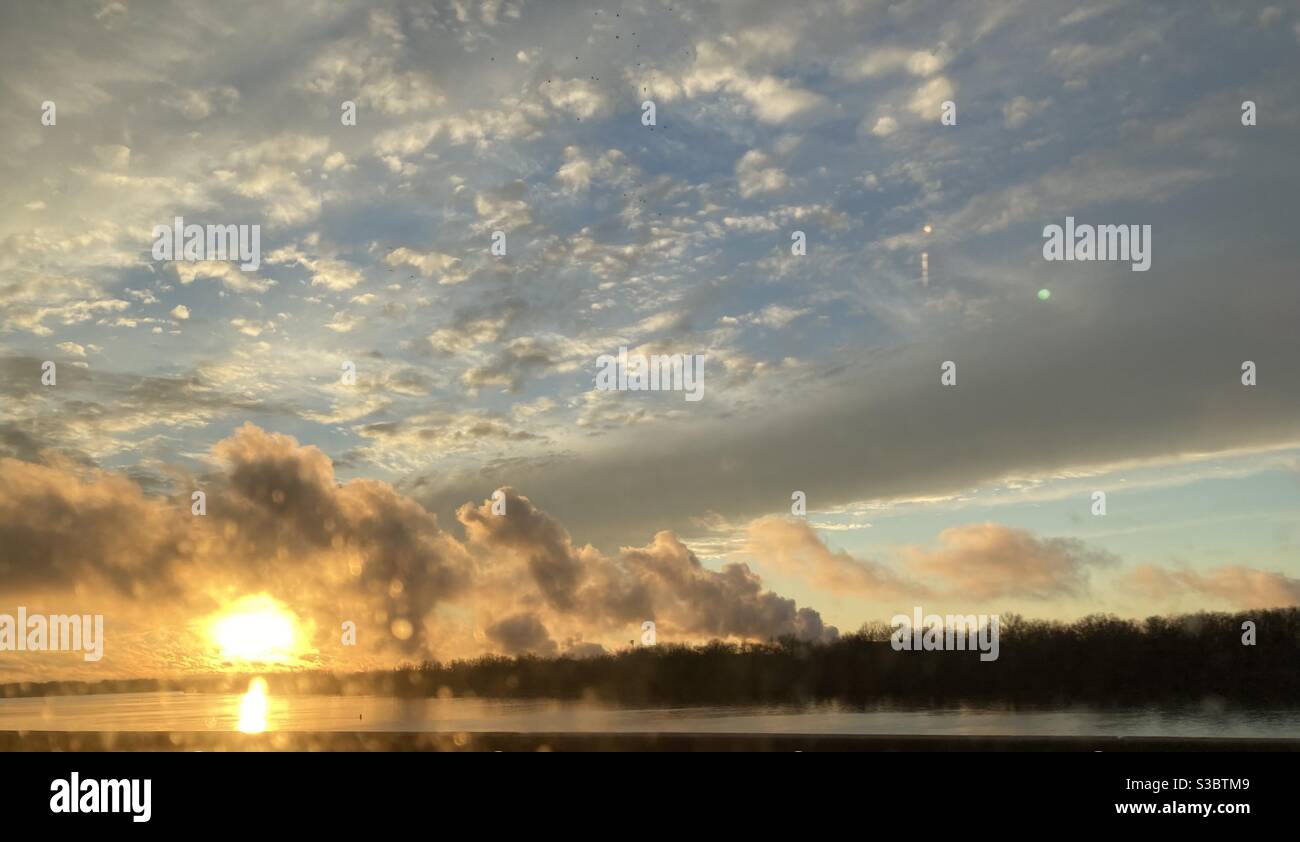 Great picture of the sun as it starts to set after the storm clouds clear way on the top of a bridge in Bordentown New Jersey. - Smartphone Captured Stock Image