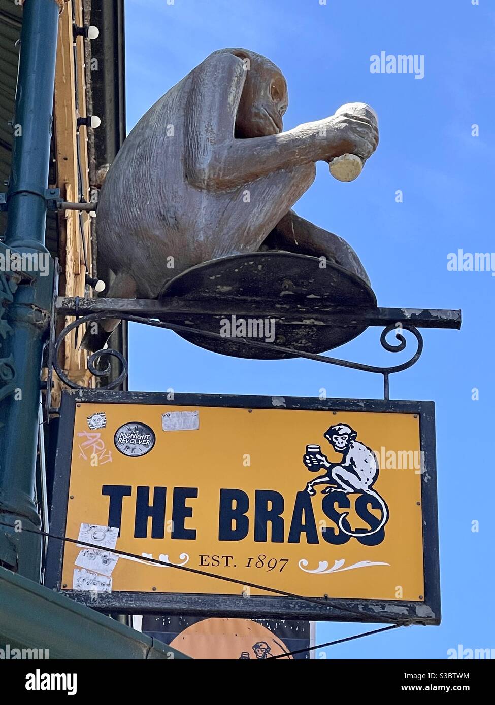 Statue of monkey holding a beer and sign for Brass Monkey hotel