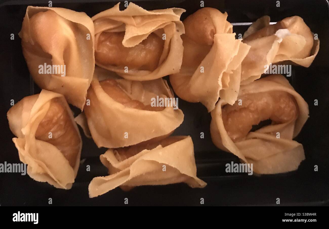 Closeup image of crispy fried prawn wontons on a black background - Smartphone Captured Stock Image