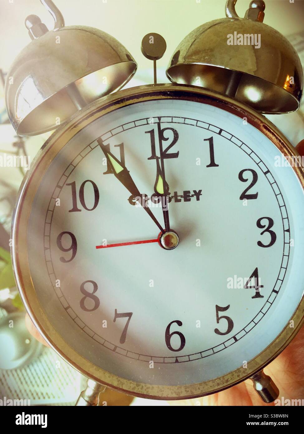 An oldfashioned analog alarm clock has two ringer bells Stock Photo