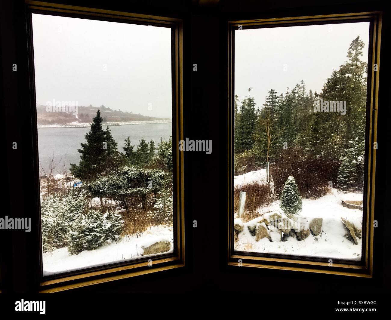Snow squall over the ocean. A cold winter’s day, Halifax, Nova Scotia, Canada. View looking out from inside a cosy cottage. - Smartphone Captured Stock Image