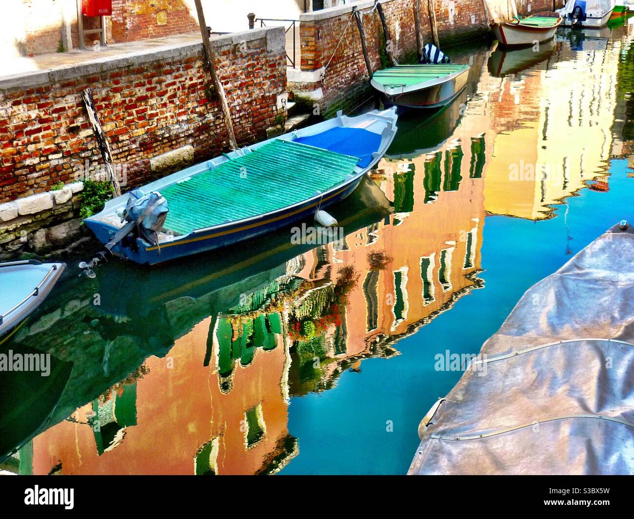 Boats on Venice canal with reflection of houses Stock Photo - Alamy