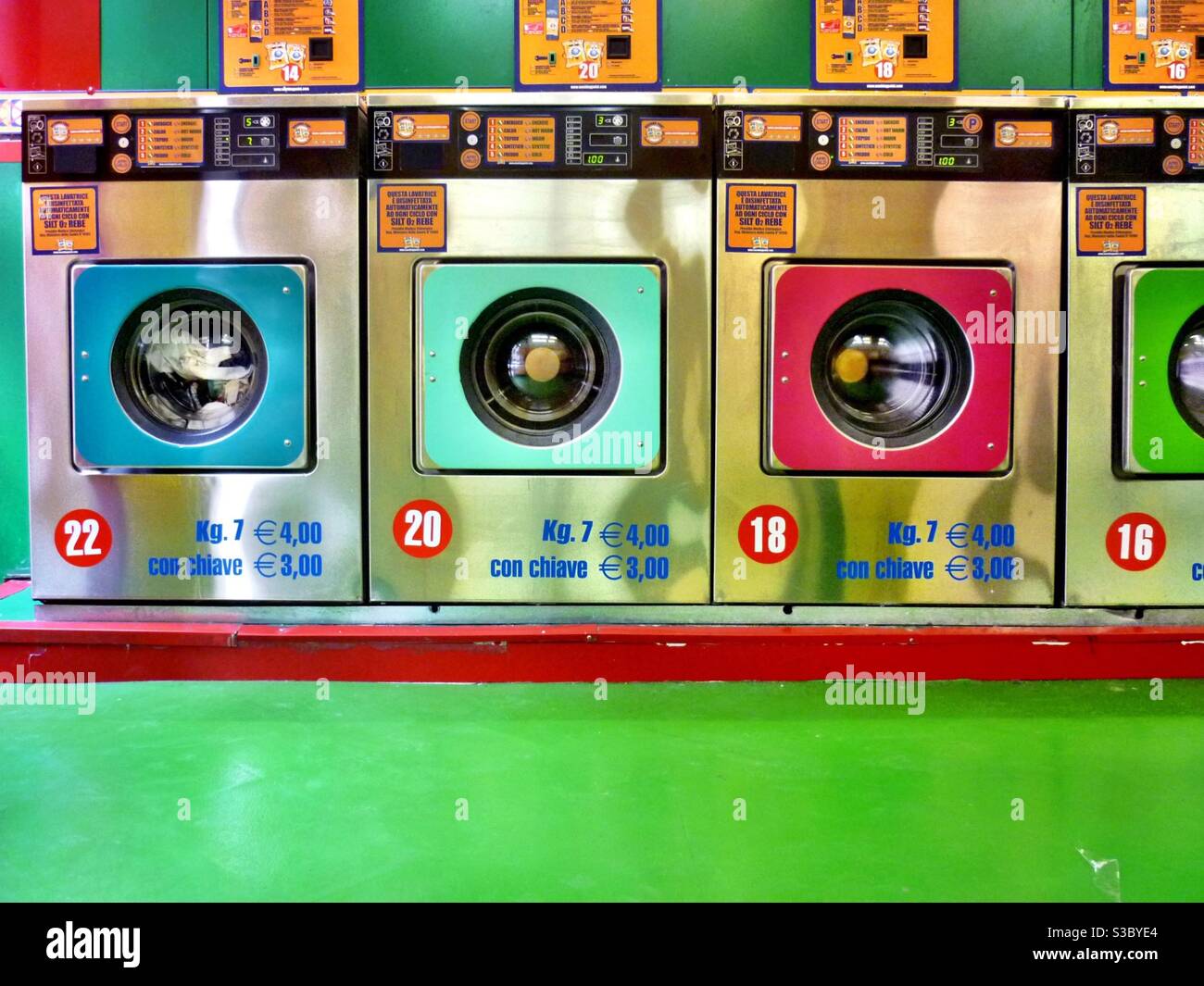 Colourful washing machines in automatic laundrette Stock Photo