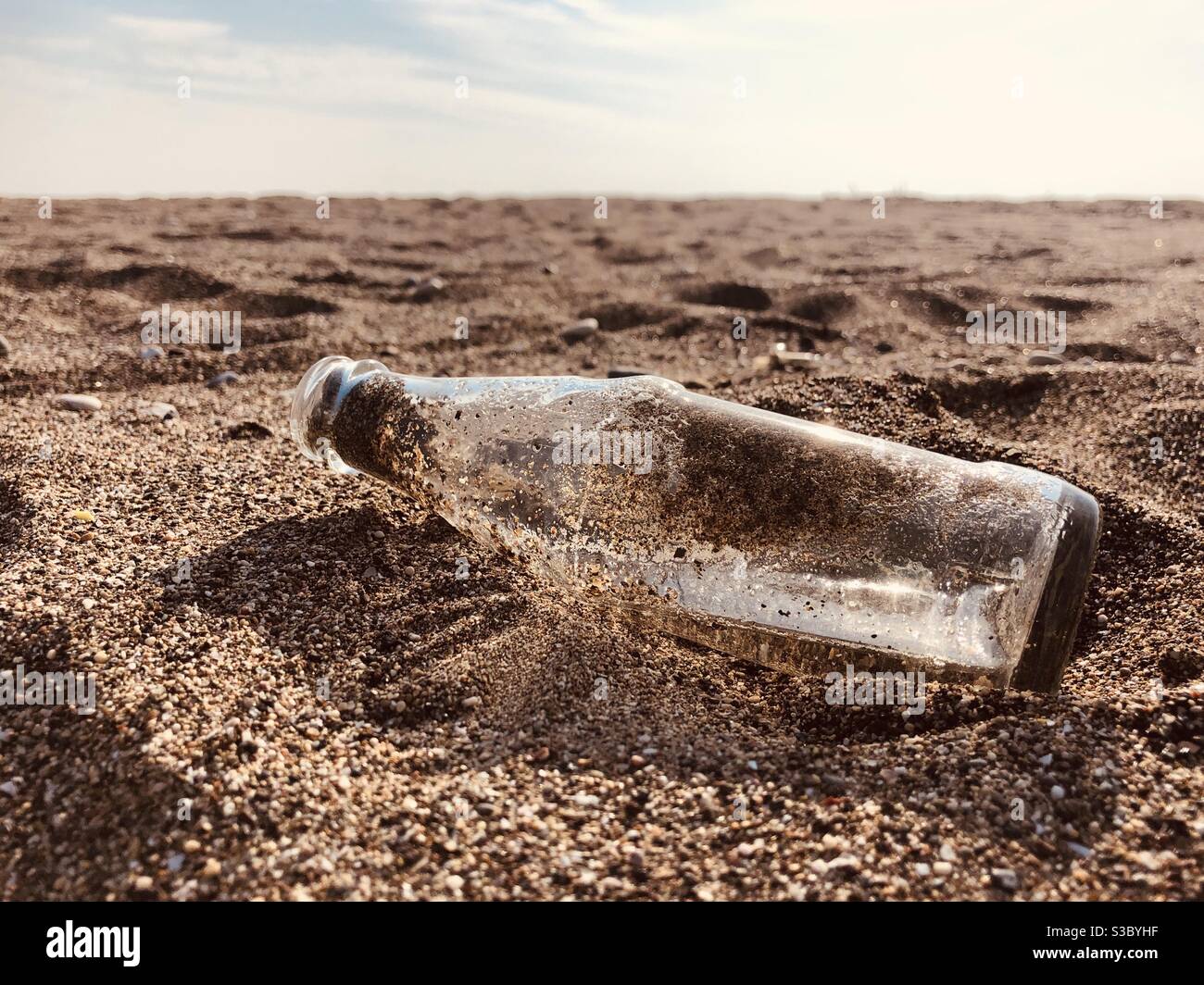 Empty bottle left on beach Stock Photo