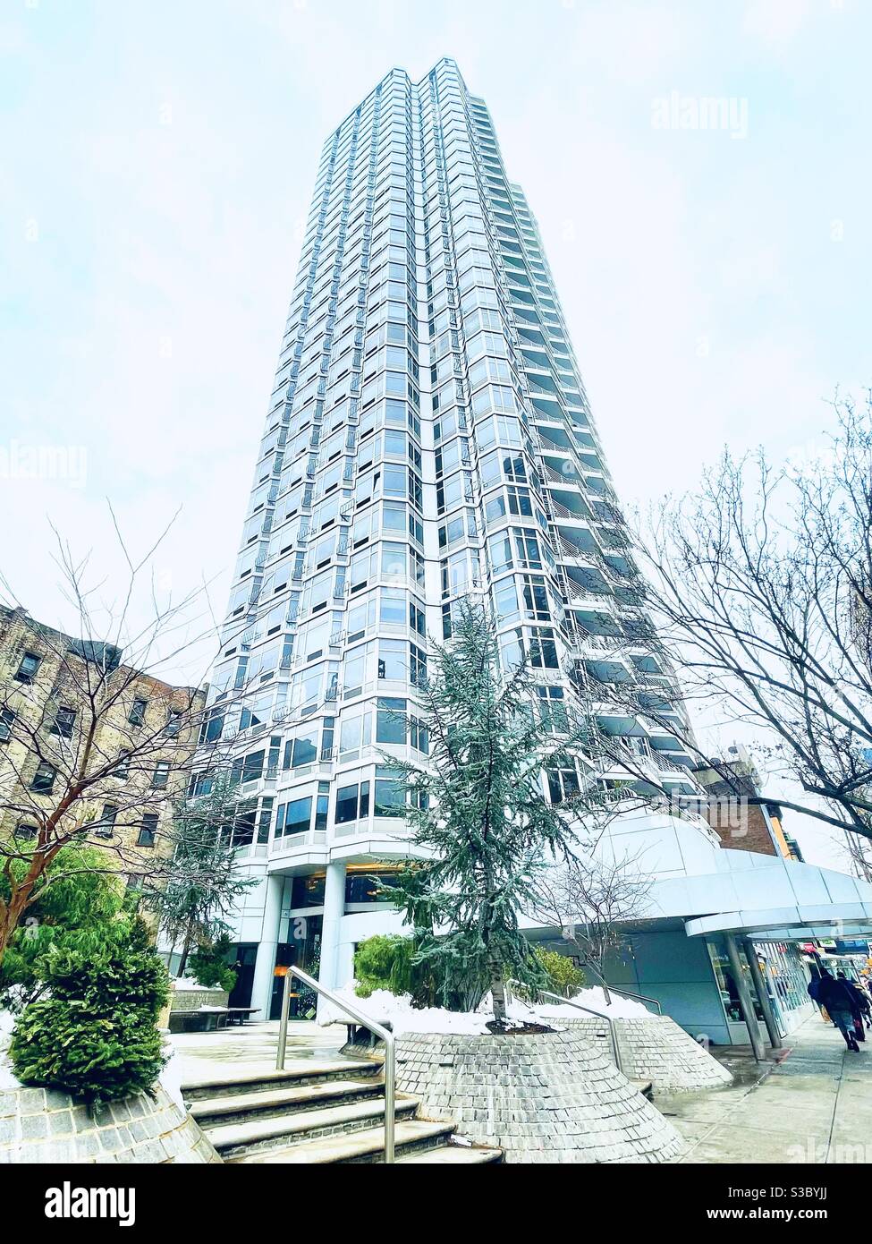 Glistening modern skyscraper full of multi-million dollar condos in New York City near Kips Bay & Murray Hill. Multi-use building has a Trader Joe’s Market beneath it. - Smartphone Captured Stock Image
