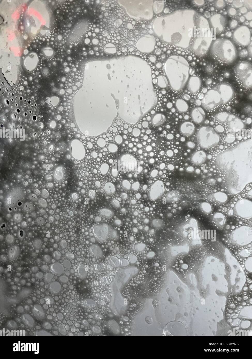 Abstract of soapy car wash suds on a windshield Stock Photo