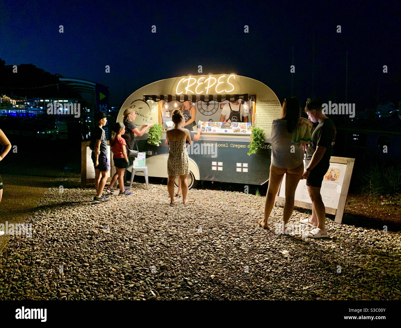 People wait beside a caravan selling crepes at Nelson Bay in regional New South Wales, Australia - Smartphone Captured Stock Image