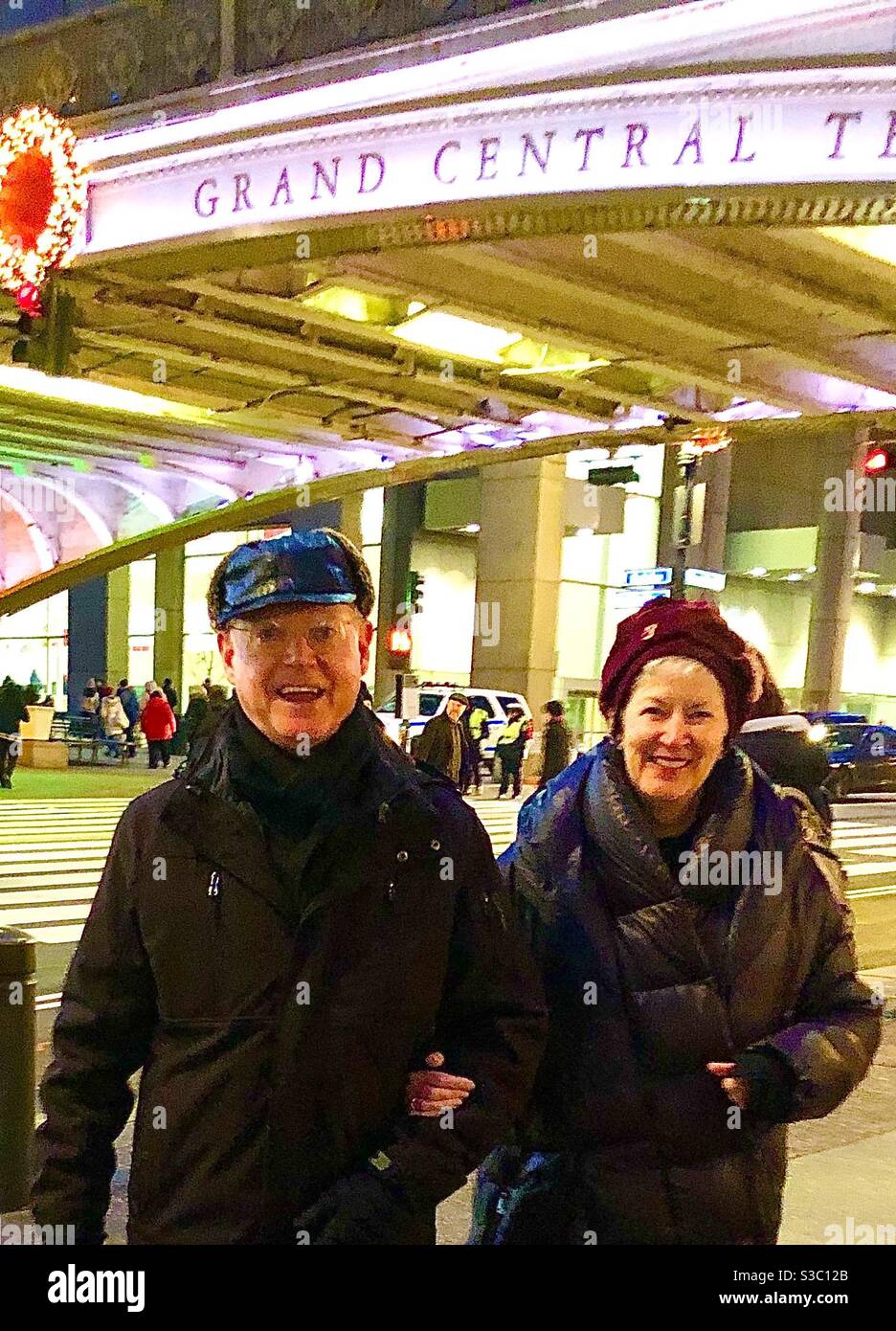 Smiling faces on a happy couple reflects the joy of the holiday season as they stroll past Grand Central Terminal in New York City. - Smartphone Captured Stock Image